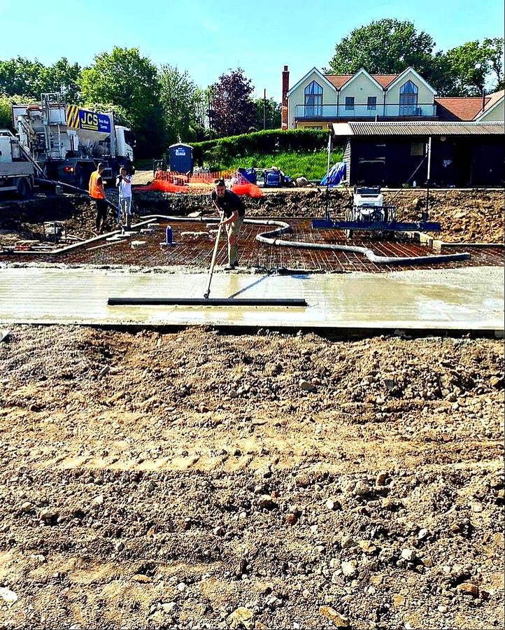 JDG Groundworks team hand-finishing concrete slab surface during pump pour, Essex