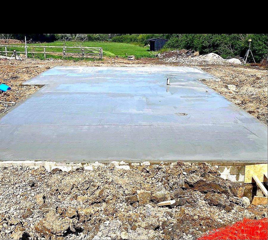 Completed precision concrete slab for Dan-Wood prefab home, Essex, with survey equipment visible